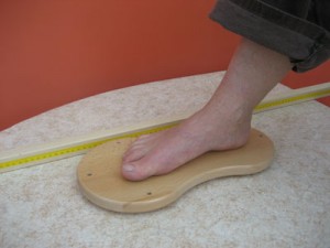 Fußarbeit: BIBER-Therapietisch in der niedrigsten Position; Patient sitzt auf der erhöhten Bobathliege; Fixierbare Messleiste zur Dokumentation des Therapieerfolges